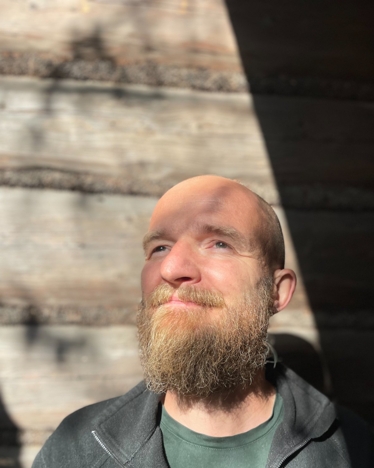 Krzysztof — psychoterapeuta, portret w świetle słońca przy drewnianej ścianie
